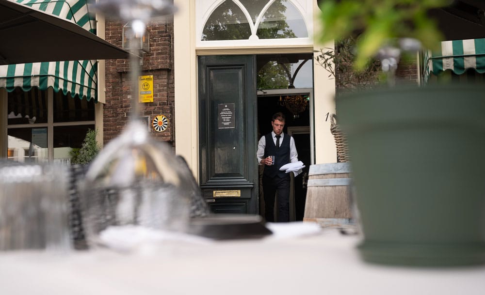 Ober loopt naar buiten bij restaurant ’t Spuihuis